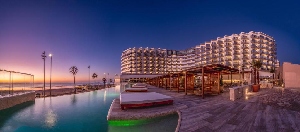 a hotel with a swimming pool in front of a building at Cádiz Bahía by QHotels in Cádiz