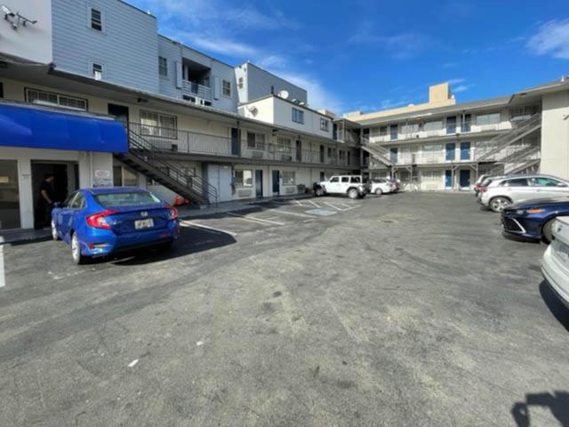 un estacionamiento con autos estacionados frente a un edificio en Motel 6 San Francisco CA Lombard Street, en San Francisco