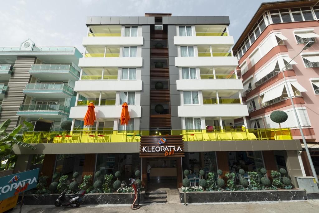 a large apartment building with a restaurant in front of it at Kleopatra Suit Hotel in Alanya