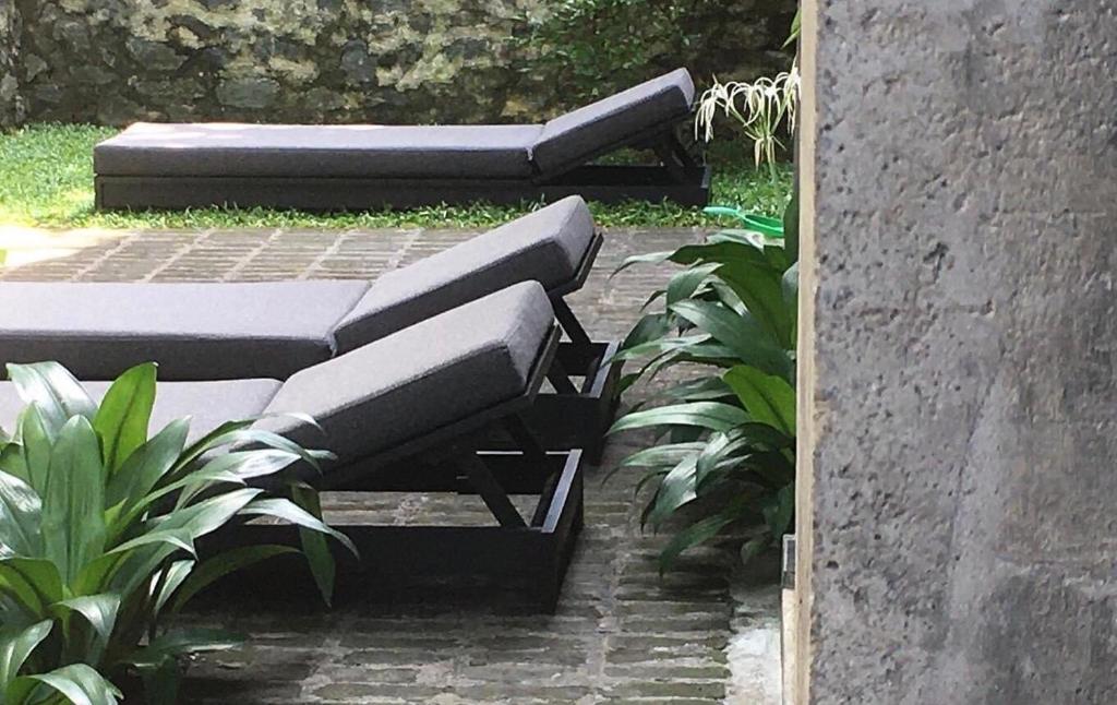 two beds sitting on a brick patio with plants at Saffron Robes Living in Hikkaduwa