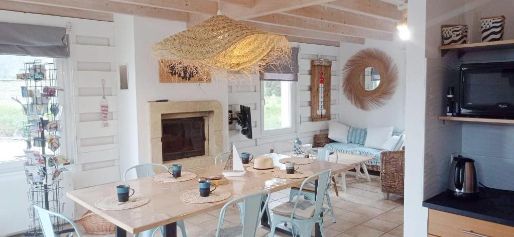 una sala da pranzo con tavolo e camino di Gîte L ' Escale 300 m à pied des plages a Plouarzel