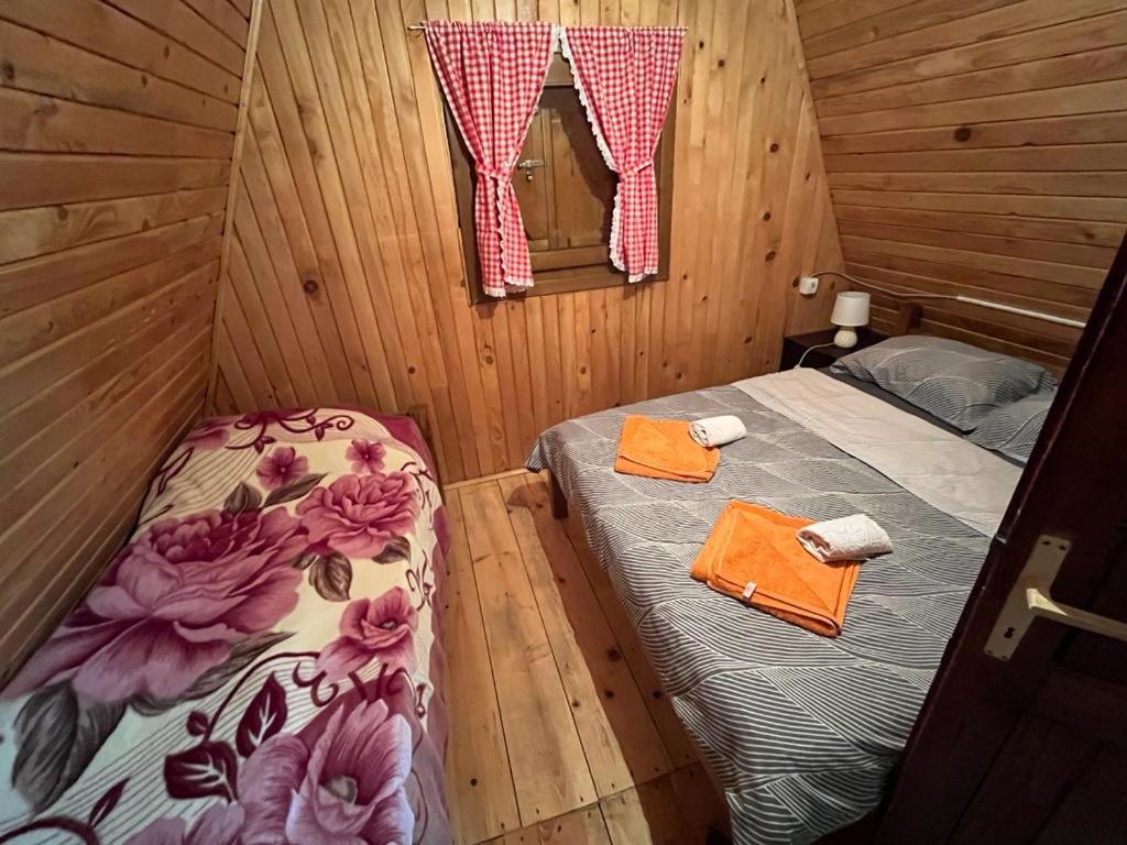 a bedroom with two beds in a wooden cabin at Golija Vikendica Česta Vrela in Raška