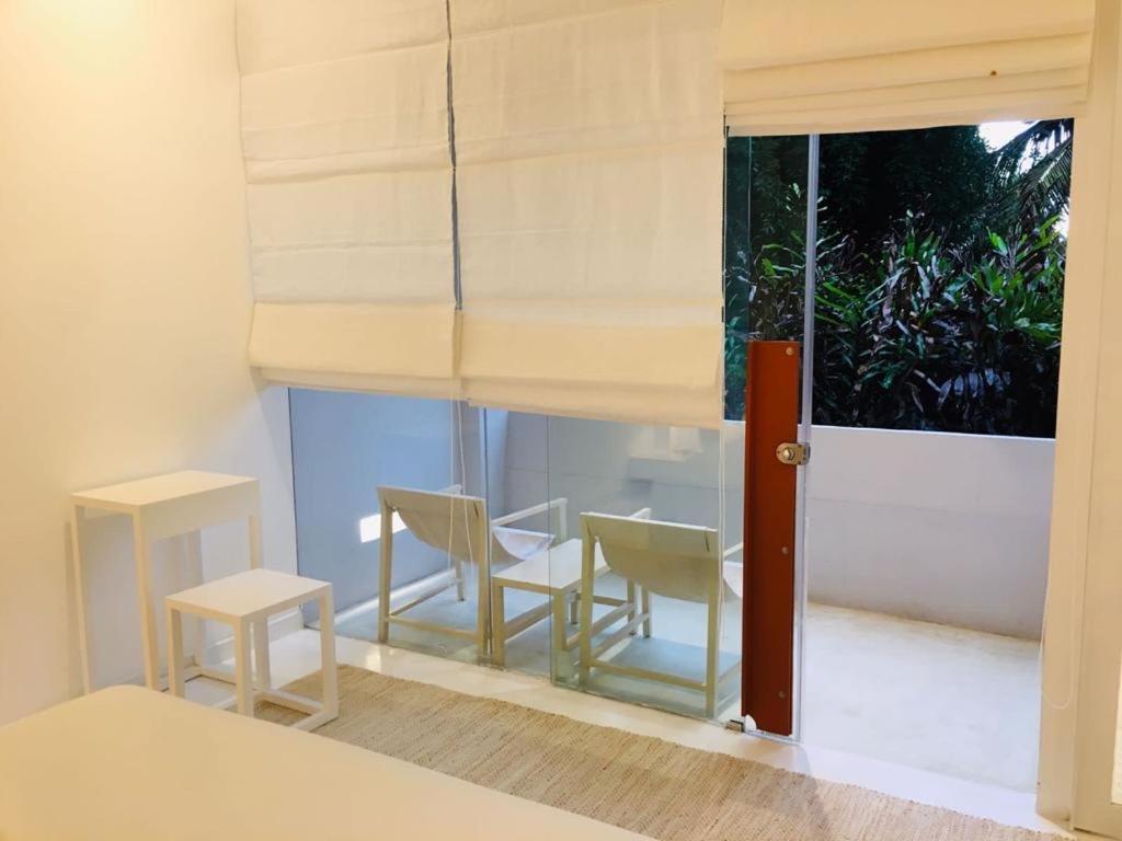 a room with chairs and a table and a window at Saffron Robes Living in Hikkaduwa