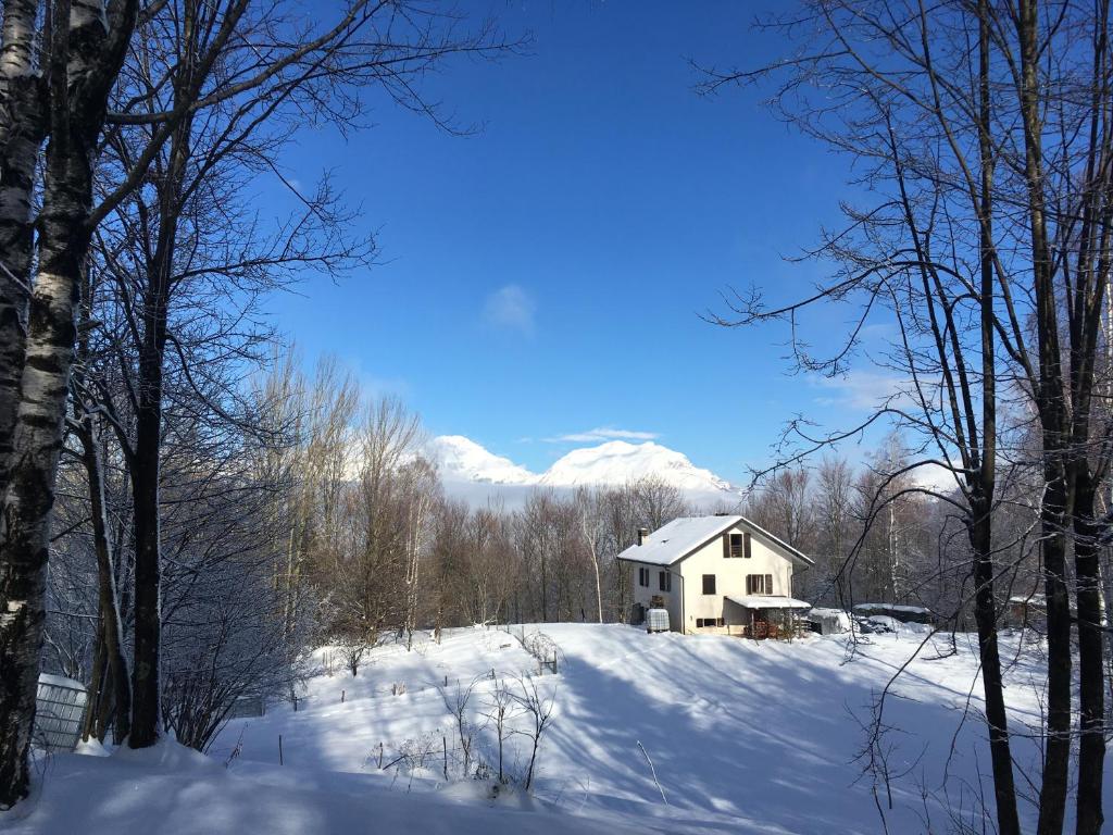 a white house on a snow covered hill with trees at Casa Betulla in Valmorel