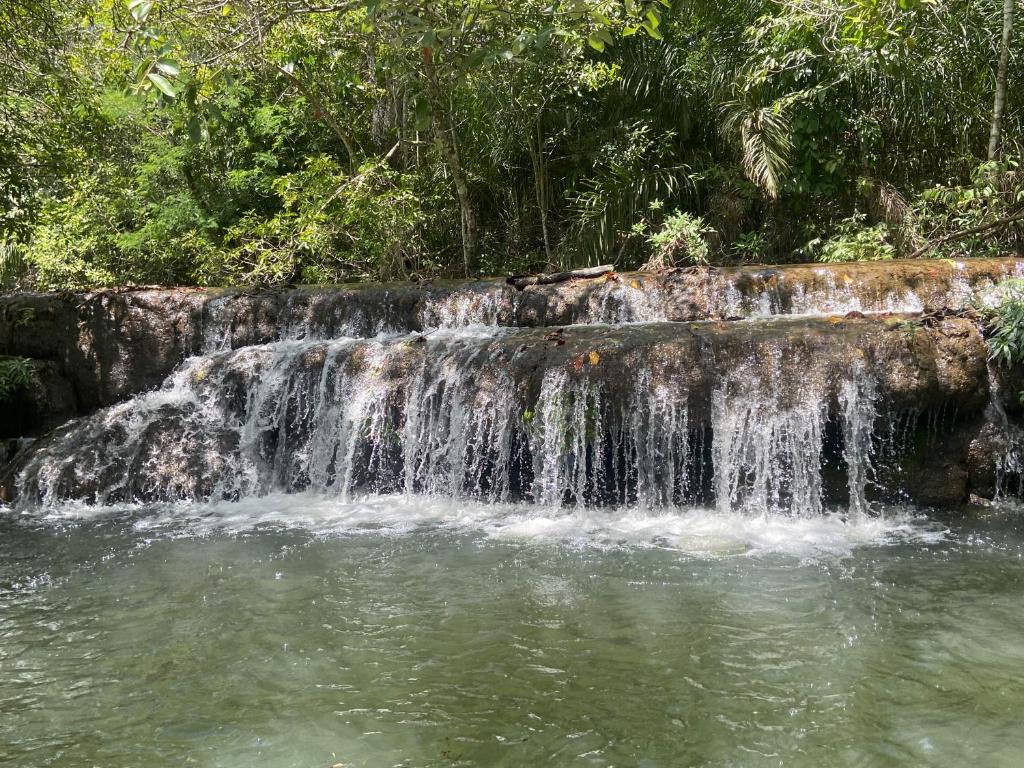 una cascada en medio de una piscina de agua en Fazenda a 15 min do centro com Rio Particular en Bonito