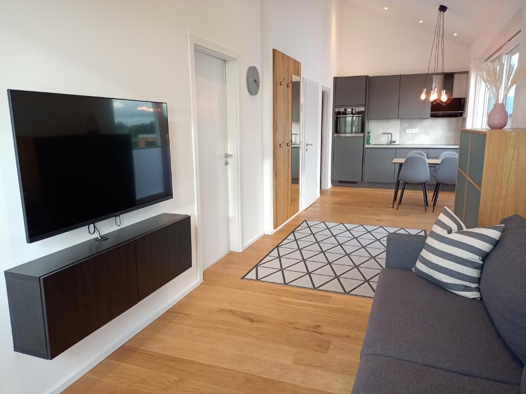 Una sala de estar con un televisor de pantalla plana en una pared. en Ferienwohnung Mundry, en Täferrot