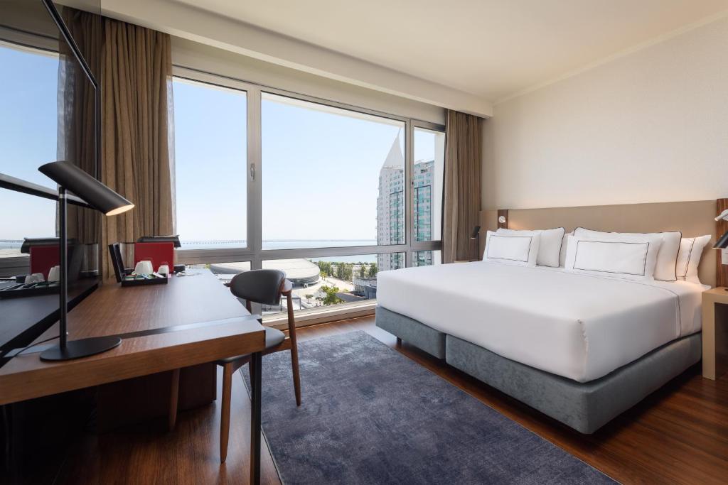 Habitación de hotel con cama y escritorio con ordenador en Melia Lisboa Oriente Hotel, en Lisboa