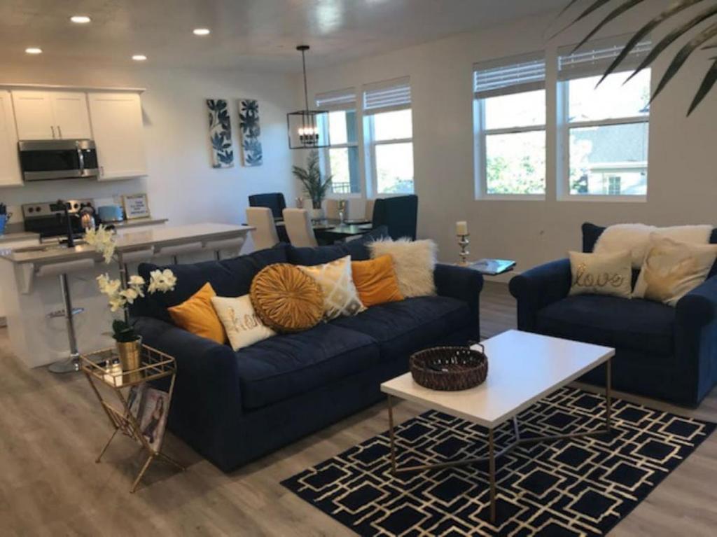 ein Wohnzimmer mit einem blauen Sofa und einem Tisch in der Unterkunft Draper Luxury Townhouse in Draper