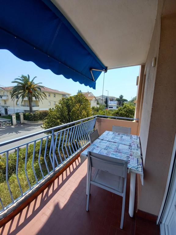 - un balcon avec une table et un parasol bleu dans l'établissement Appartement Frejus Plage, à Fréjus