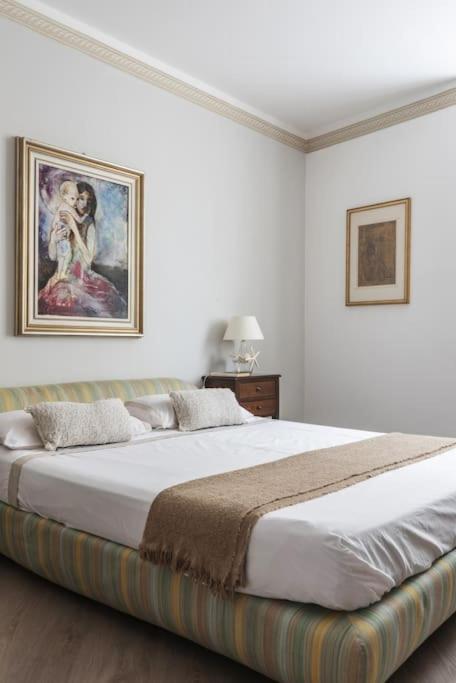 a bedroom with a large bed with a painting on the wall at Caprera Flexyrent NO air conditioning - Seafront in Santa Margherita Ligure