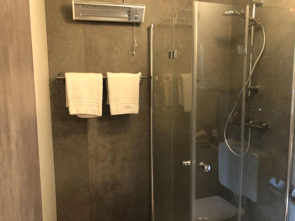 een badkamer met een douche en een glazen douchecabine bij Tiny Häuschen in Ossiach