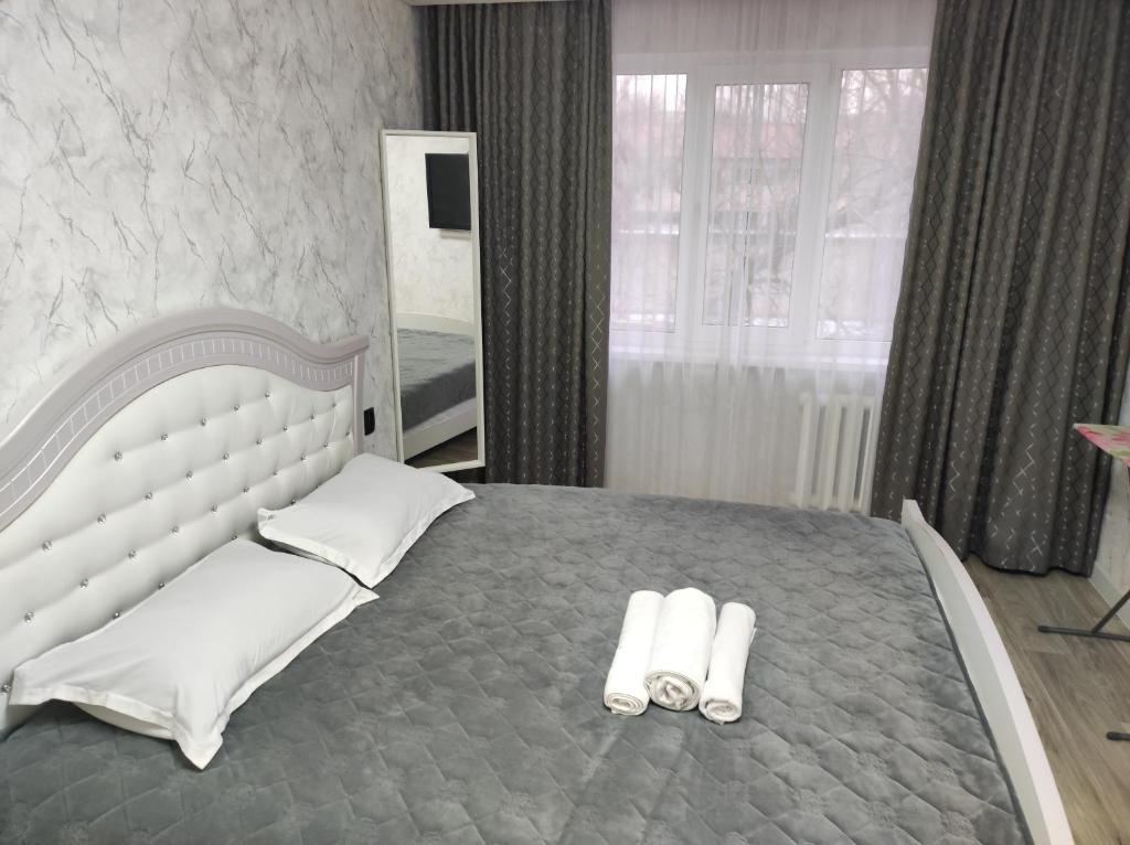 Квартира однокомнатная VIP في أورالسك: غرفة نوم بسرير كبير عليها منشفتين