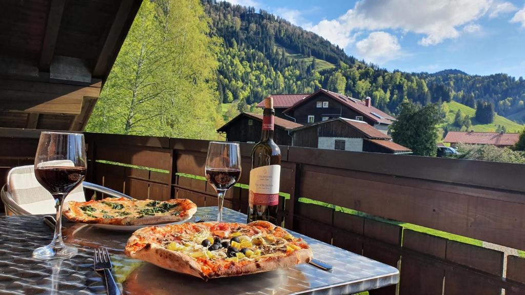 Dos pizzas en una mesa con copas de vino en Five Seasons en Oberstaufen