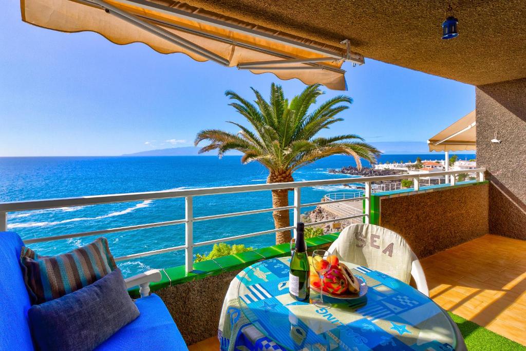 d'un balcon avec une table et des chaises donnant sur l'océan. dans l'établissement Costa Isora, à Puerto de Santiago