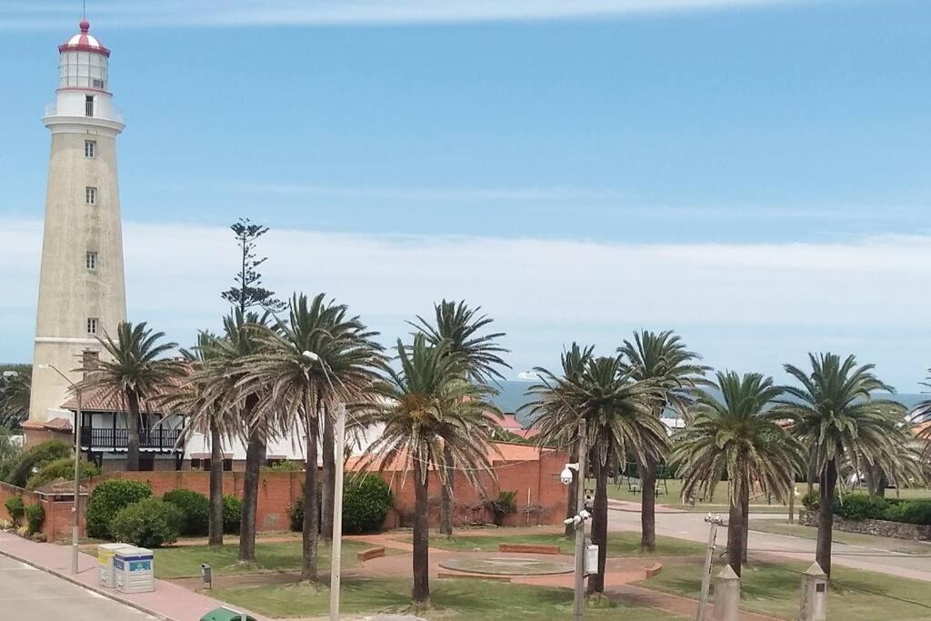 een vuurtoren met palmbomen voor een straat bij Apartamento en Península con vista a las Islas 1 Dorm y Estar in Punta del Este