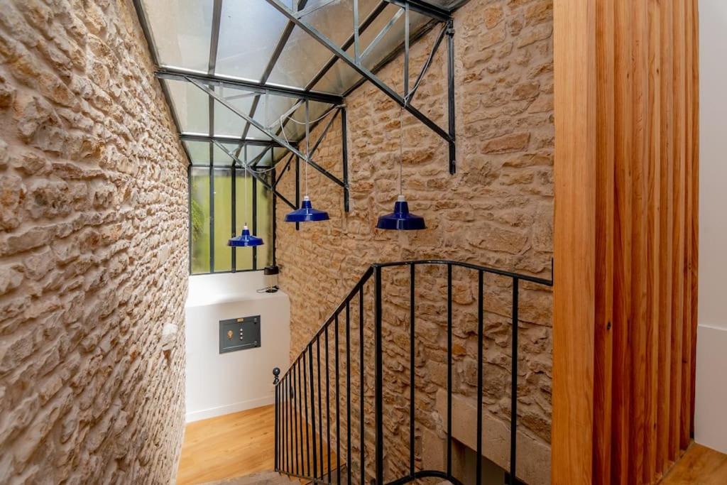 uma escadaria num edifício com uma parede de pedra em Maison nichée au coeur des vignes proche de Givry em Givry
