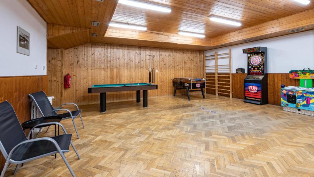 a room with a ping pong table and chairs at Wellness Hotel Šedý Vlk in Harrachov