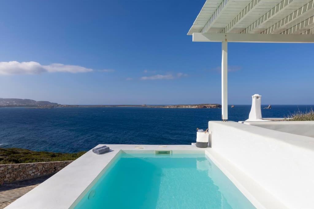 una piscina al lado de una casa con el océano en Thea Villas Paros, Villa Turquoise, private pool, en Kampos