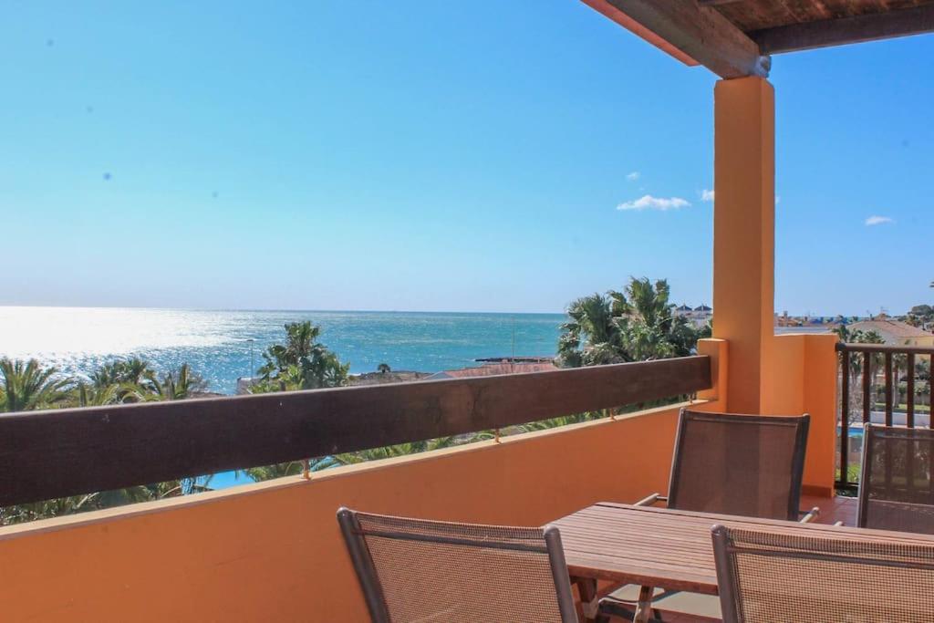 Apartamento Alcocebre Beach Resort في الكوسيبري: شرفة مع طاولة وكراسي والمحيط