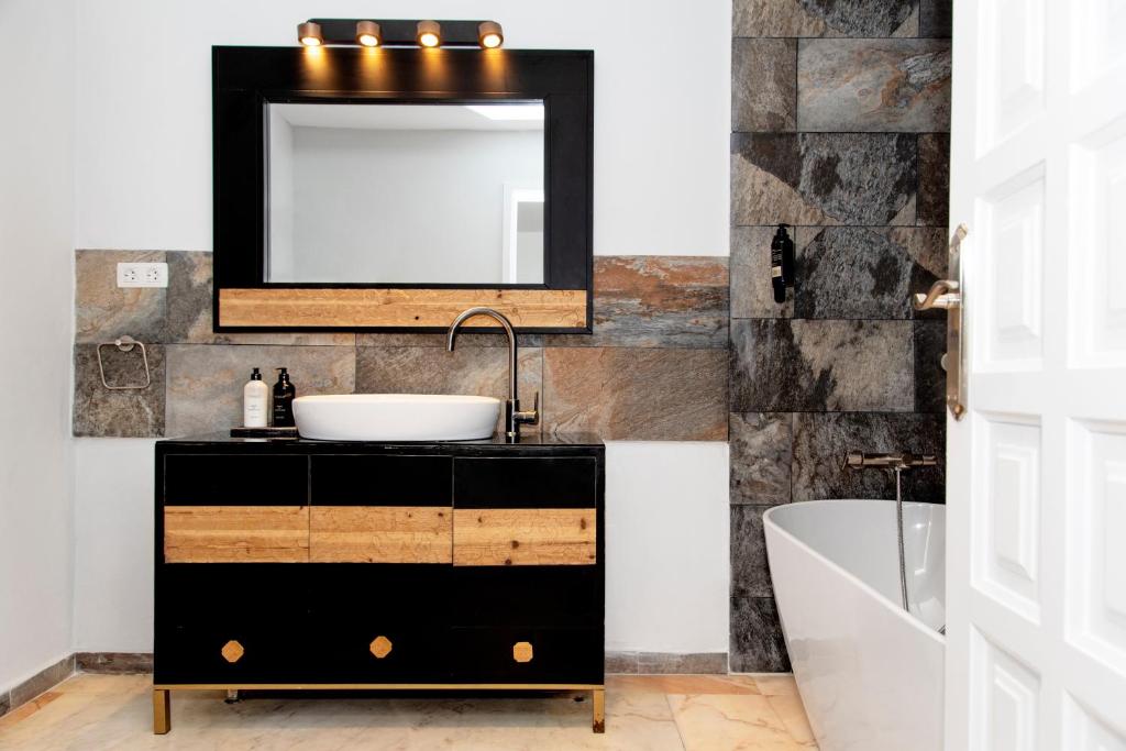 a bathroom with a sink and a mirror at Villa Los Flamencos by Veaco- Beachfront & pool in Corralejo