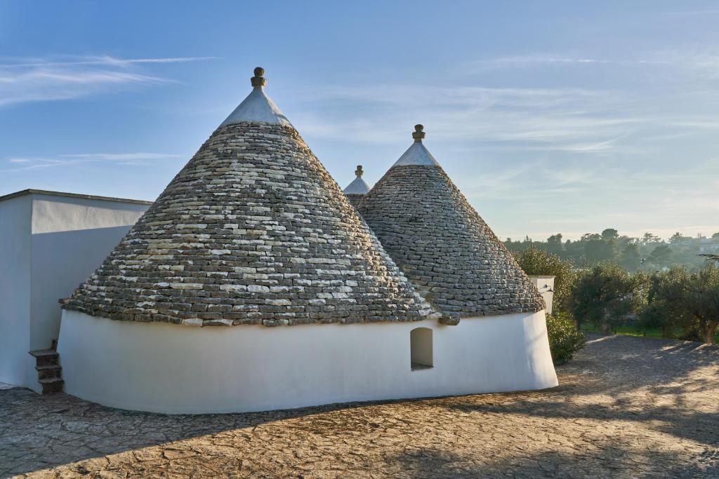 a building with a thatched roof with a sky at Trulli OraziO in Monopoli