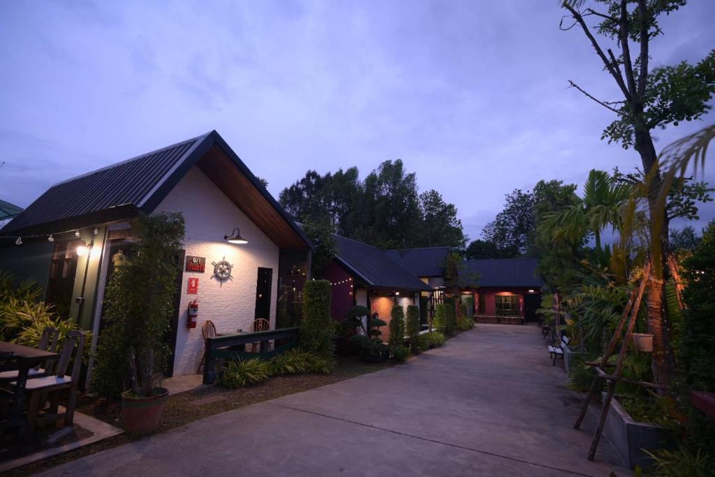 Hugs Home & Cafe Trang في ترانغ: مجموعة مباني مع ممشى في الليل