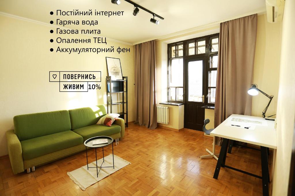 a living room with a green couch and a table at City Garden Apartments in Odesa