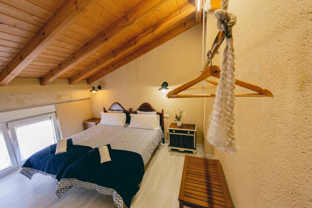 a bedroom with two beds in a room with wooden ceilings at Las Postas del Perionda in Calzada de los Molinos