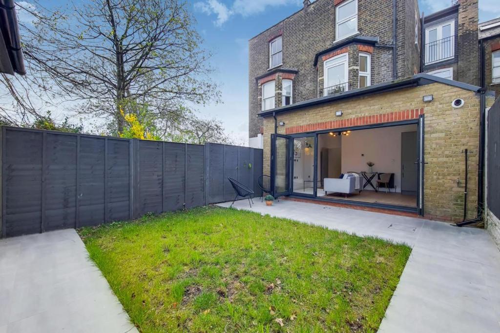 a backyard of a house with a fence at Brand New Luxury 2-Bed Apartment in London in London