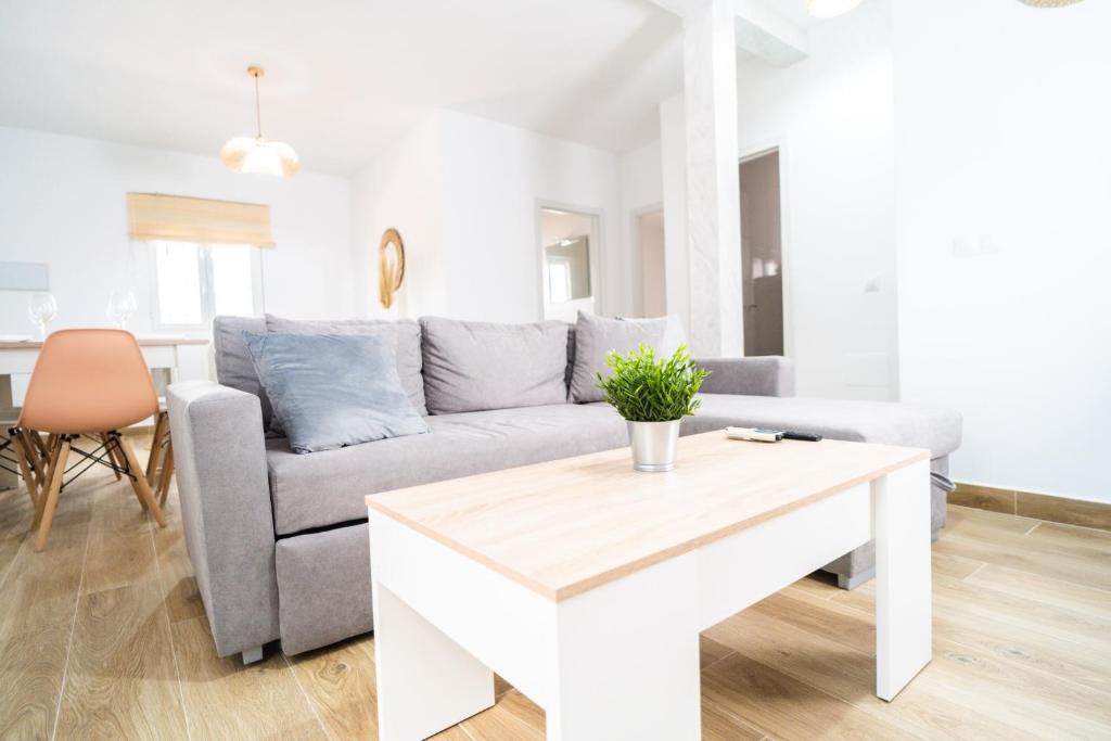 uma sala de estar com um sofá e uma mesa em Apartamento Patio Real em Ronda