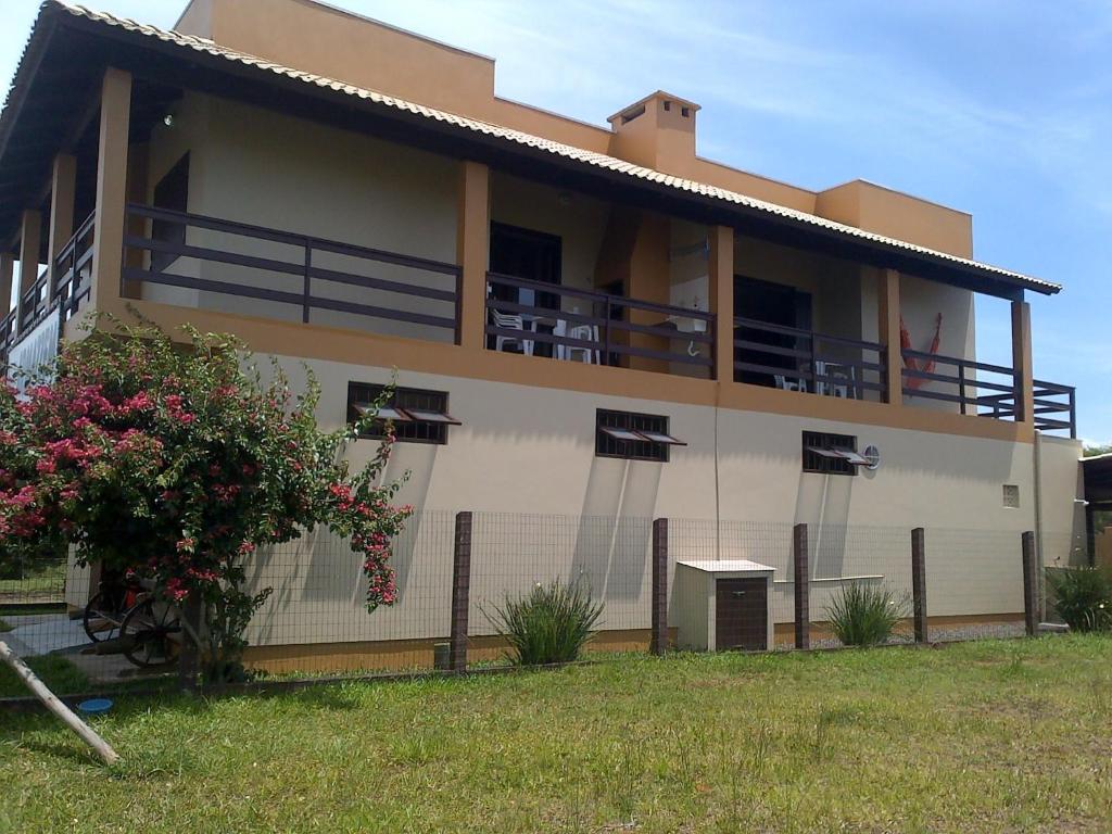 a house with a balcony and a yard at Apartamentos Di Armazzem in Torres