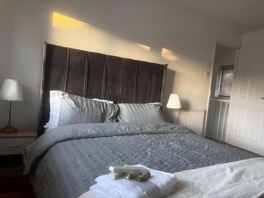 Home in Basildon, Essex في باسيلدون: غرفة نوم بسرير كبير عليها حشرتين محشوتين