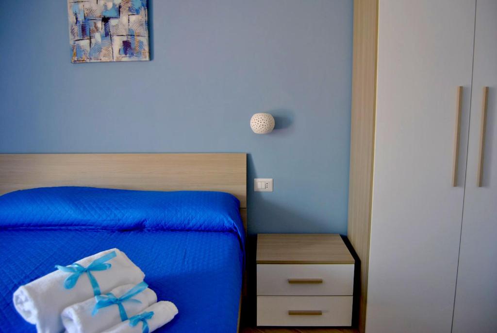 - une chambre bleue avec un lit et un mur bleu dans l'établissement B&B Il Gioiello, à Formia