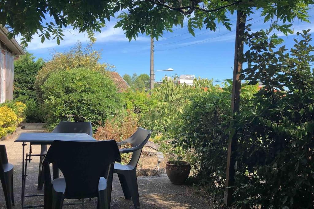 einen Tisch und Stühle im Garten in der Unterkunft Maison à Arcachon avec piscine hors-sol in Arcachon