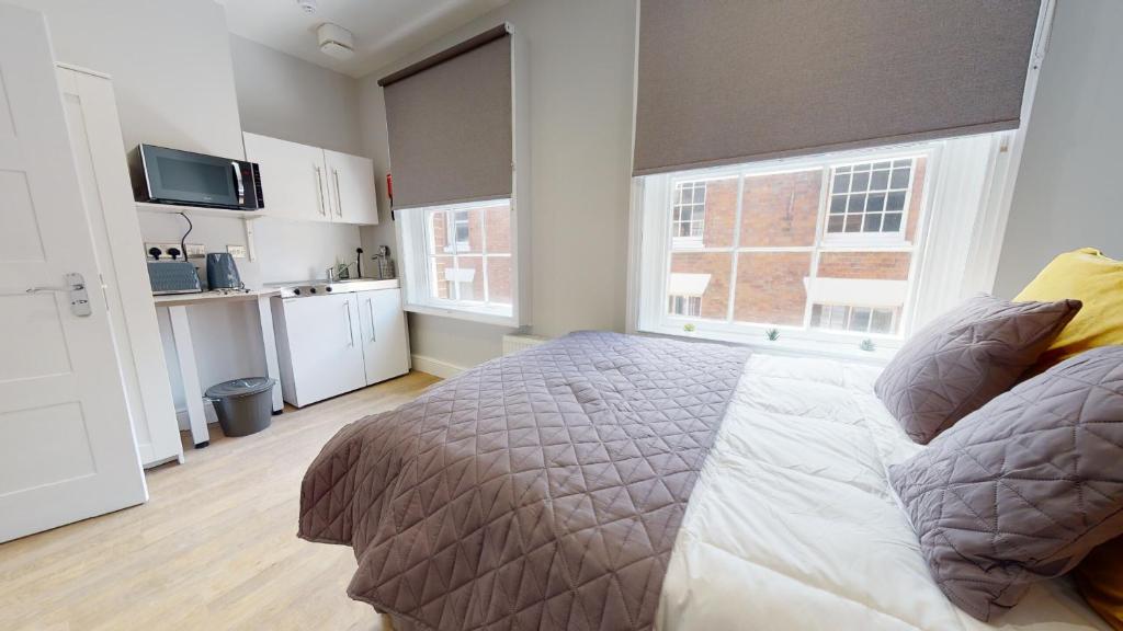 a bedroom with a bed and a large window at 1 Castle Yard in Coventry