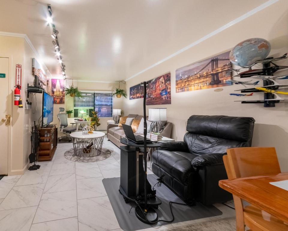 a living room with a leather couch and a table at Booking.Com Exxlusive: Fully Furnished One Bedroom Entire Apartment With Full Size Bed. For One Person Or Couple, Soulmate Positive Friendship in Brooklyn