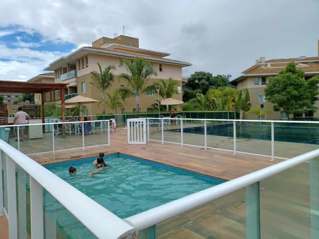 a couple of people in the swimming pool at a resort at Lindo Flat em resort silencioso e aconchegante in Brasilia