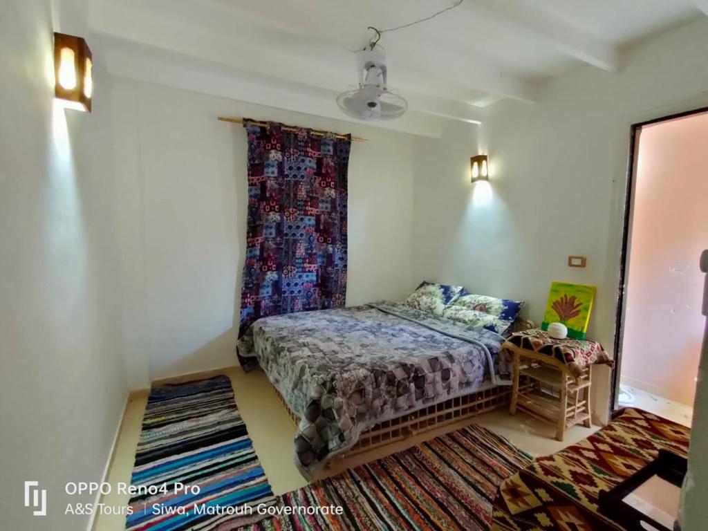 um pequeno quarto com uma cama e uma janela em A&S House em Oásis de Siuá