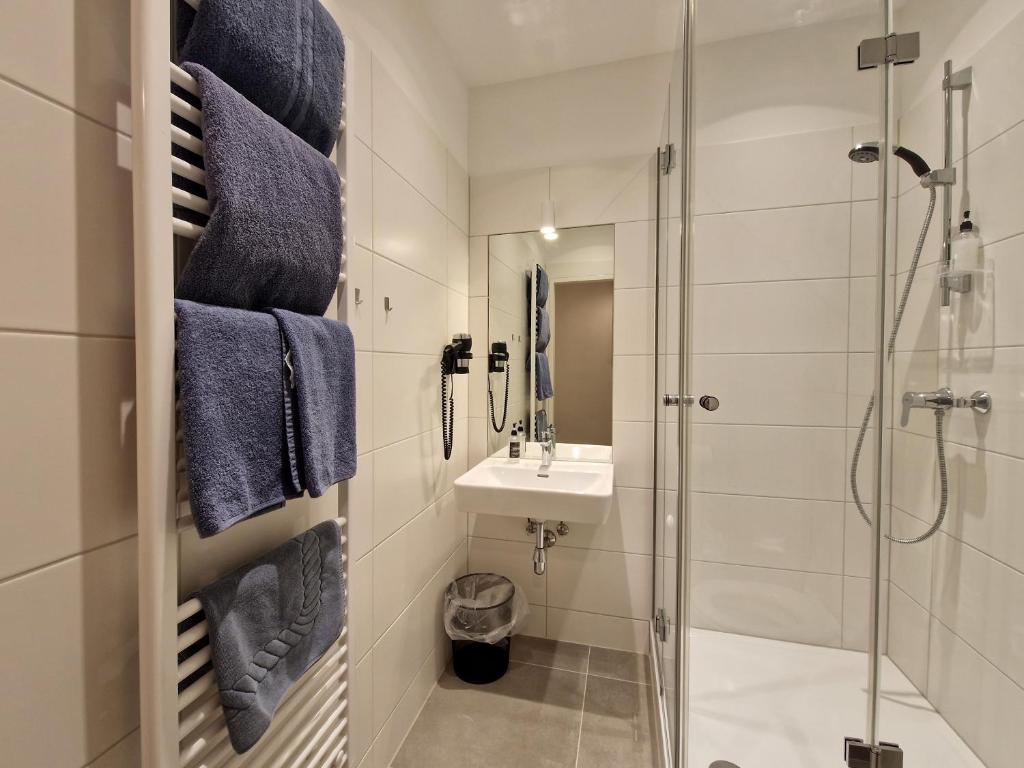 um banheiro com pia e chuveiro em Pension Mozart - Newly Renovated em Viena