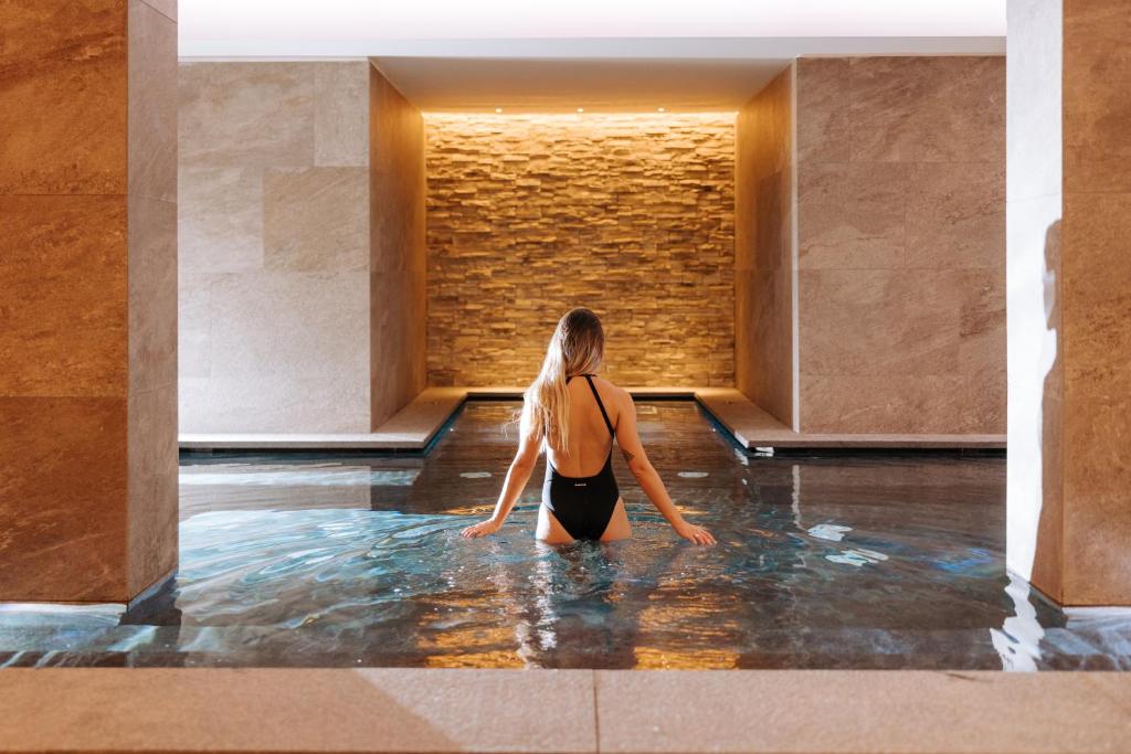 a woman sitting in the water in a building at Valtur Cervinia Cristallo Ski Resort in Breuil-Cervinia