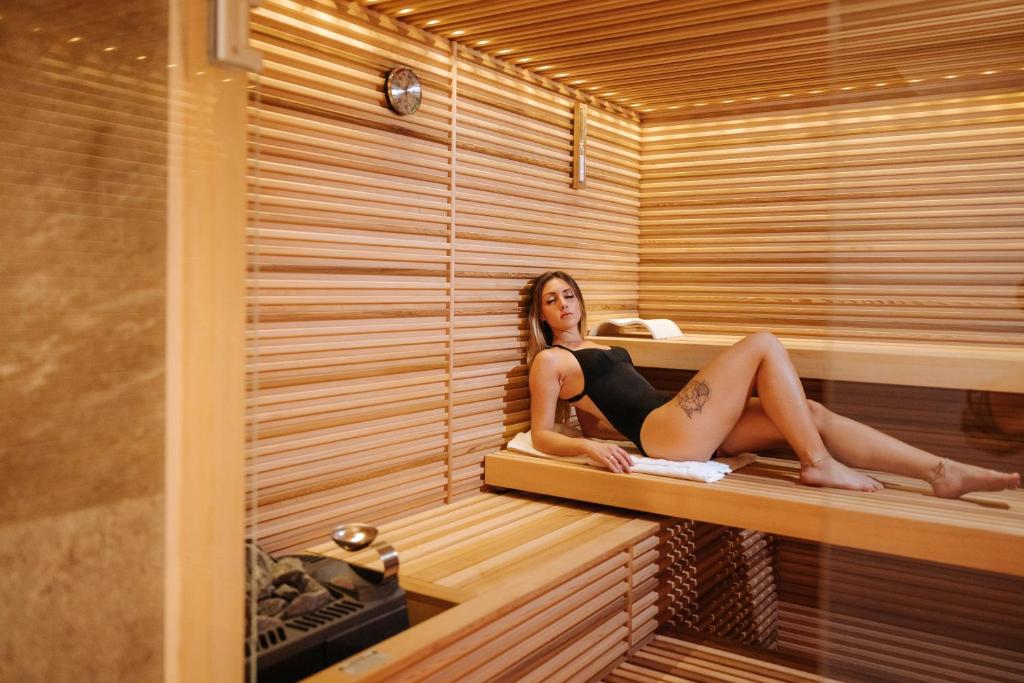 a woman is sitting in a sauna at Valtur Cervinia Cristallo Ski Resort in Breuil-Cervinia