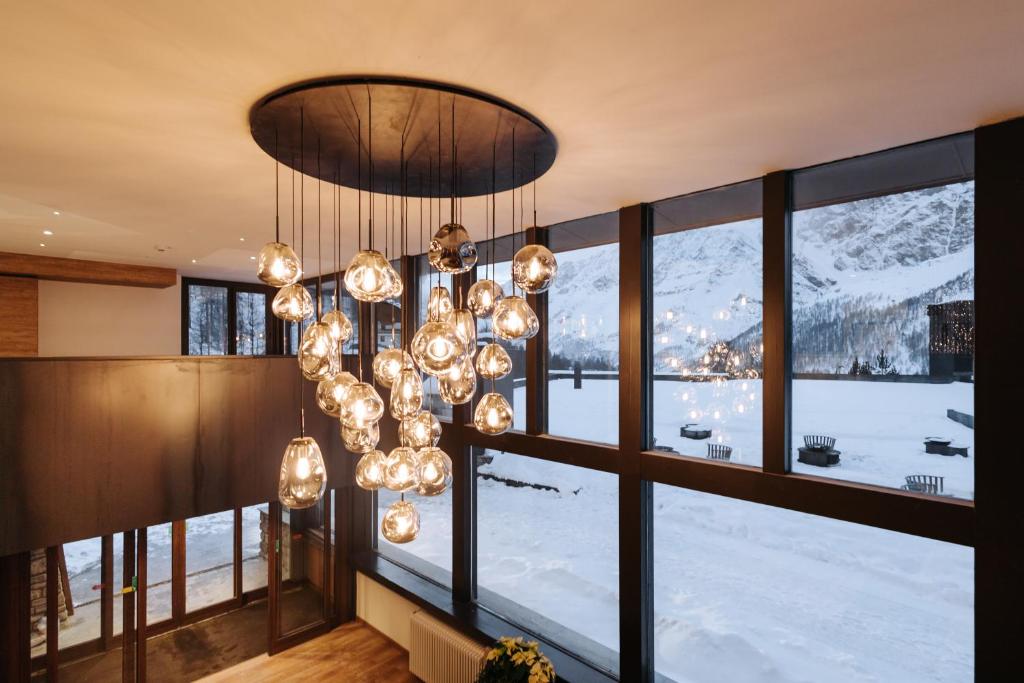 a room with a large window and a chandelier at Valtur Cervinia Cristallo Ski Resort in Breuil-Cervinia