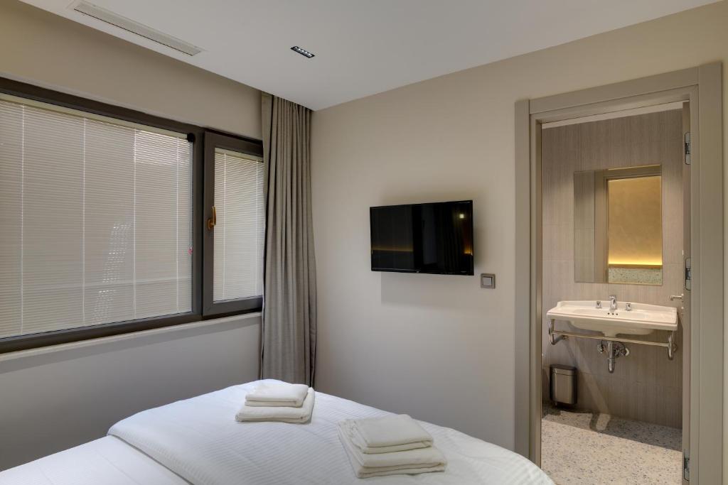 ein Schlafzimmer mit einem Bett und einem Waschbecken sowie einem TV in der Unterkunft 21 Rooms Hotel in Istanbul