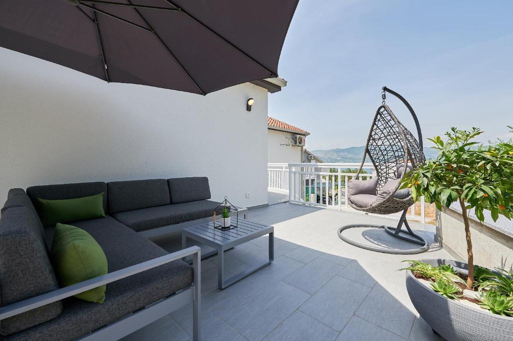 een patio met een bank en een schommel op een balkon bij Apartment Adrian2 in Trogir