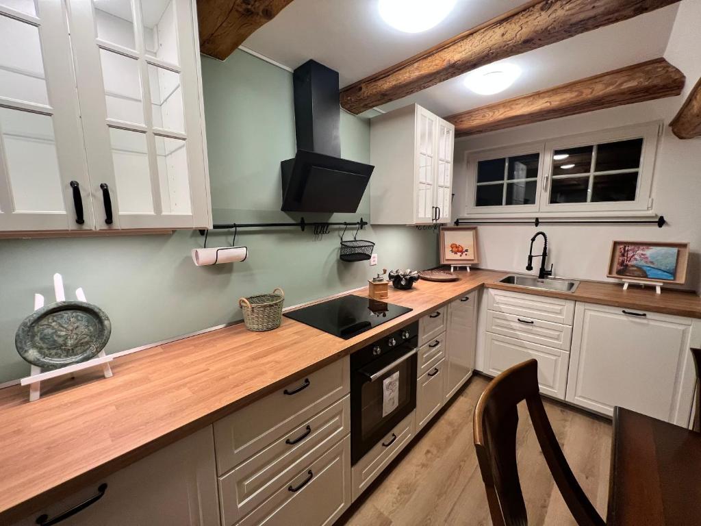 une cuisine avec des placards blancs et un comptoir en bois dans l'établissement Idyllischer Bauernhof mit Charme, à Benken
