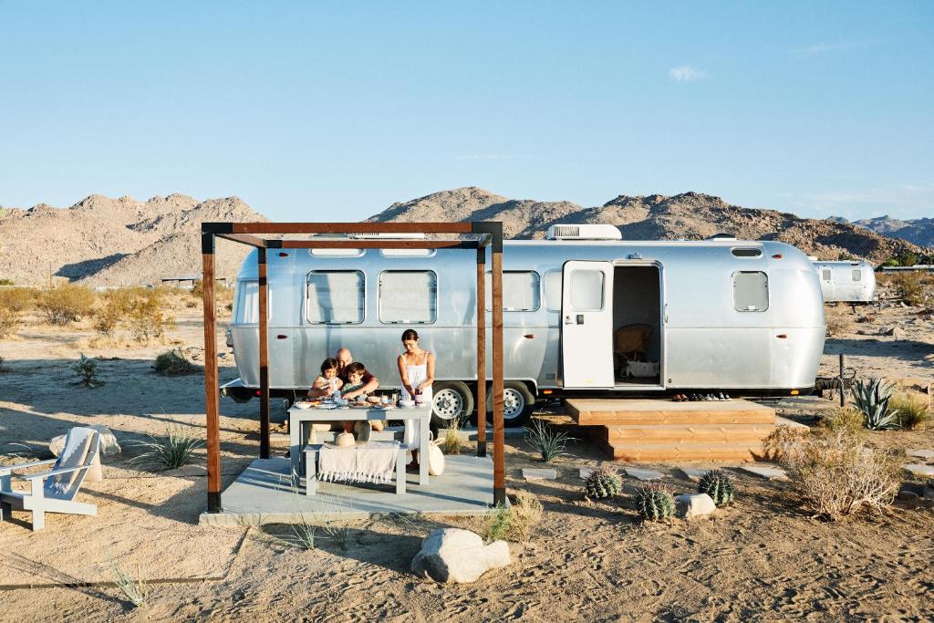 約書亞樹的住宿－AutoCamp Joshua Tree，一群坐在拖车前的人