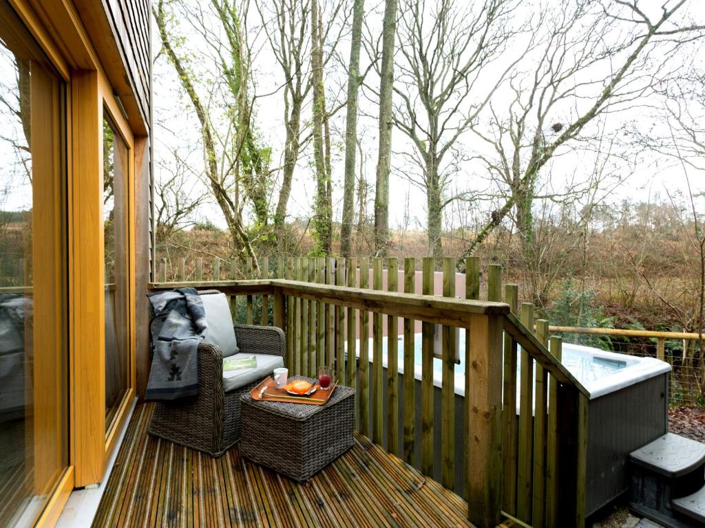 a porch with a chair and a table on a deck at Lodge 9 in Wareham