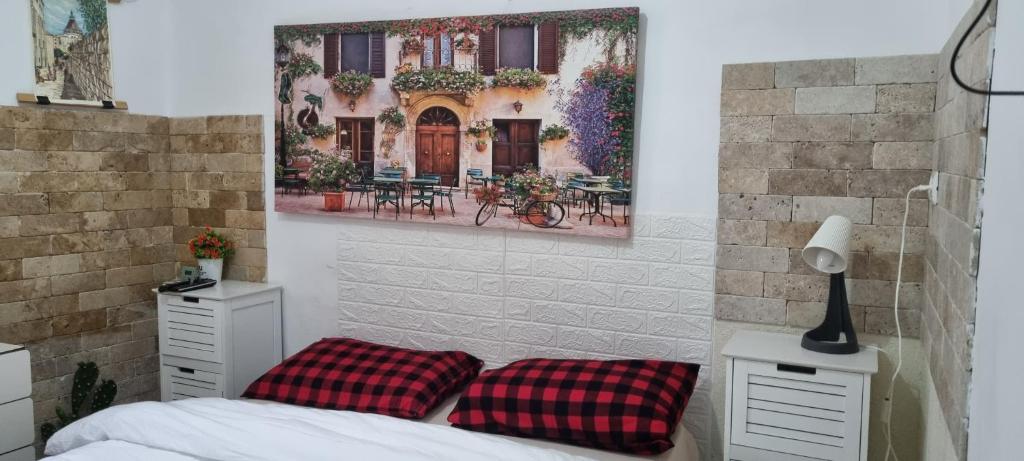 a bedroom with a bed with two red pillows at La Casetta in Nazareth