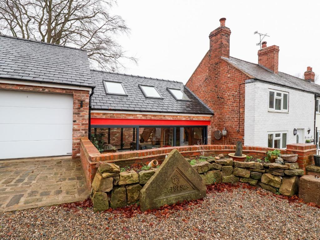 a home with a garage and a brick house at Smithy Cottage in Wrexham