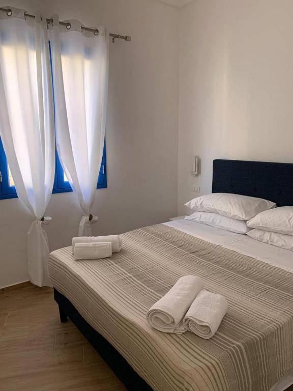 a bedroom with a large bed with towels on it at Struttura Le Gemme in Marettimo